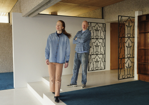 Foto av en mann og en dame som står inne i et åpent rom.